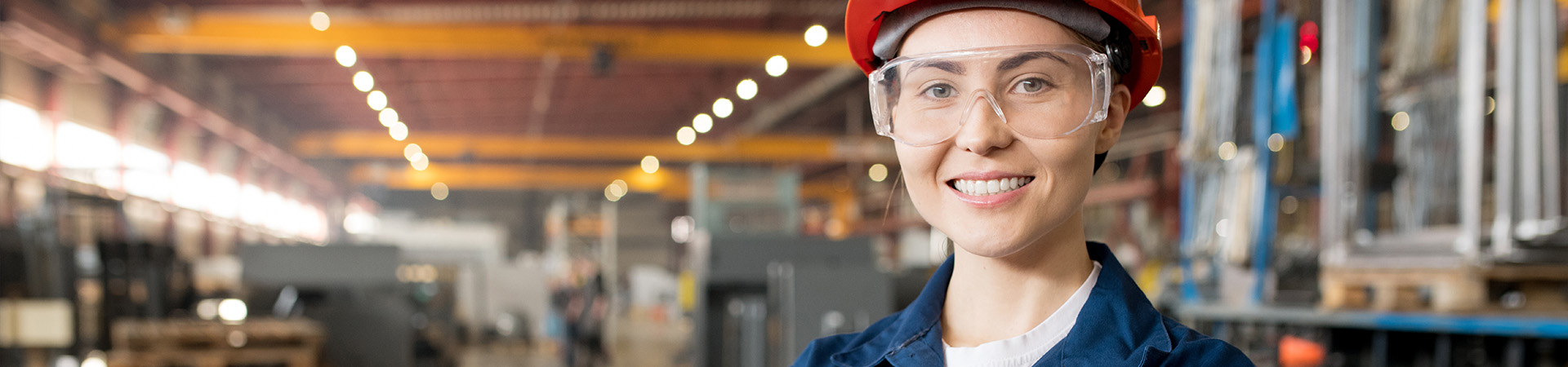 Frau mit Schutzhelm und Brille im Lager
