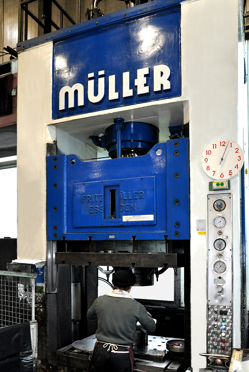 Employee operating a large forming machine